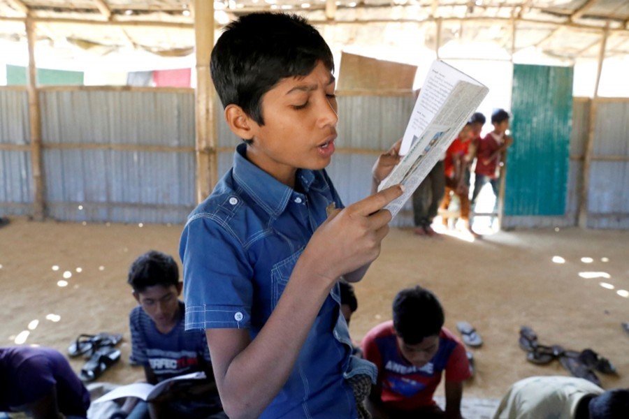 A child reads a book in a make-shift school run by Rohingya teachers in Kutupalong refugee camp in Cox’s Bazar, Bangladesh, on February 07, 2019 — Reuters/Files