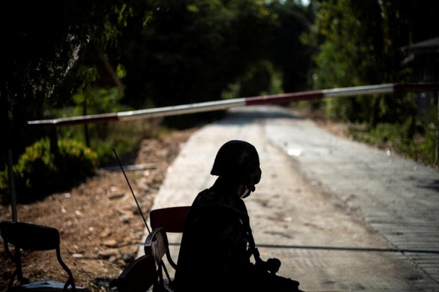 A Thai soldier sits in front of a blocked road leading to the Thailand-Myanmar border where fighting between the Myanmar army and ethnic minority rebels still continues, Dec 19, 2021. REUTERS/Athit Perawongmetha/File