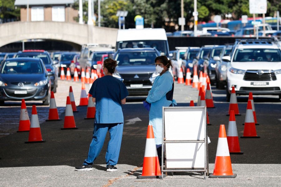 Healthcare workers wait for the next vehicle at a coronavirus disease (COVID-19) testing clinic as the Omicron coronavirus variant continues to spread in Sydney, Australia, December 30, 2021. REUTERS/Nikki Short