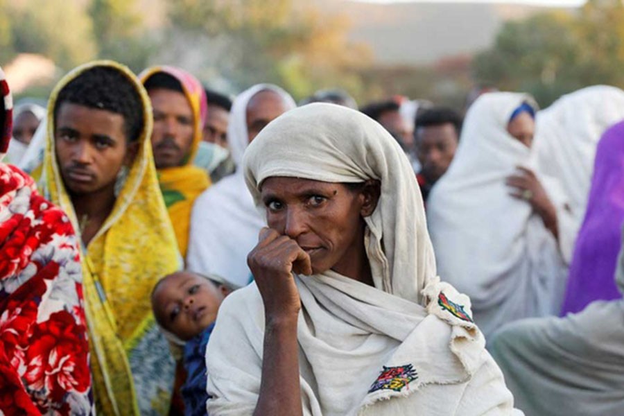 FILE PHOTO: A woman stands in line to receive food donations, at the Tsehaye primary school, which was turned into a temporary shelter for people displaced by conflict, in the town of Shire, Tigray region, Ethiopia, March 15, 2021. To match Special Report ETHIOPIA-CONFLICT/FRACTURED GIANT REUTERS/Baz Ratner/File Photo