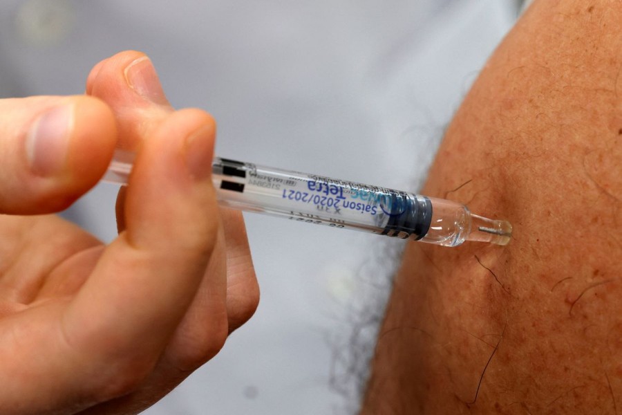 A doctor vaccinates a patient as part of the start of the seasonal influenza vaccination campaign in Gouzeaucourt, France, October 13, 2020. REUTERS/Pascal Rossignol/File Photo