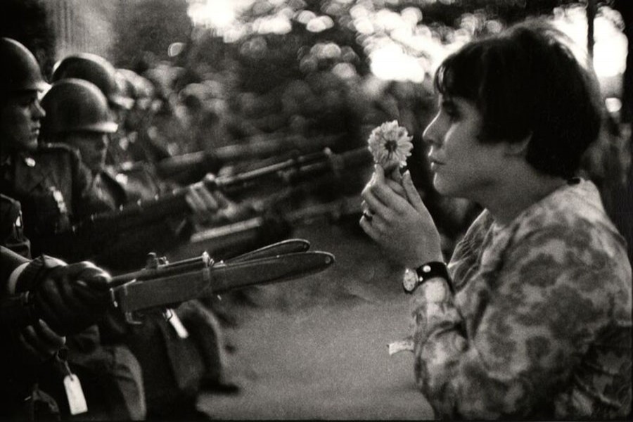  Jan Rose Kasmir, a protester holding a flower in front of the firearms of Police during an anti Vietnam war rally in Pentagon in 1967.