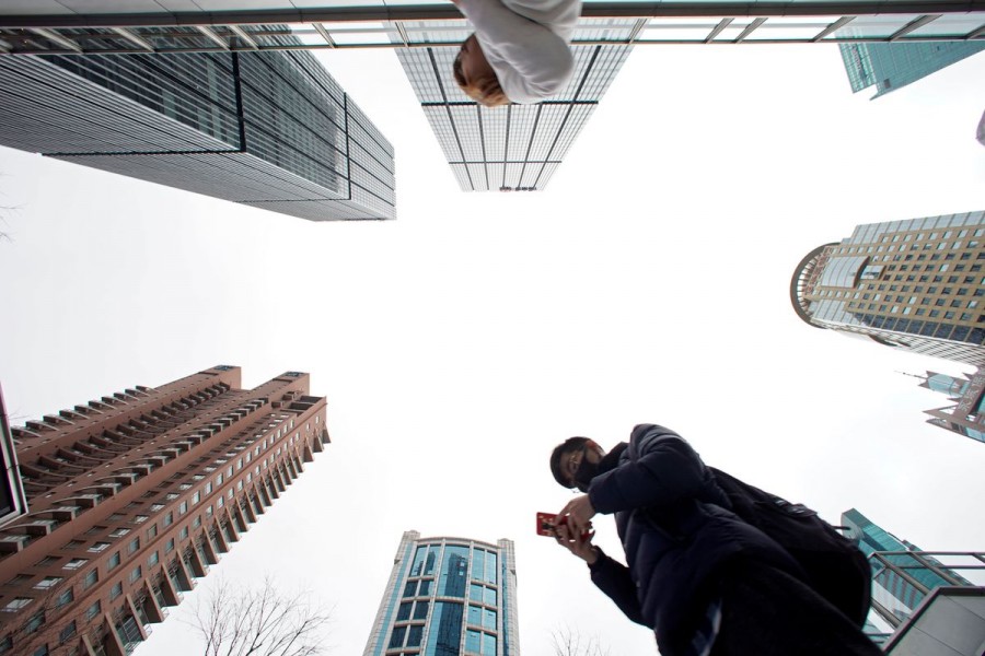 A man checks phone at Lujiazui financial district in Pudong, Shanghai, China March 14, 2019. REUTERS/Aly Song