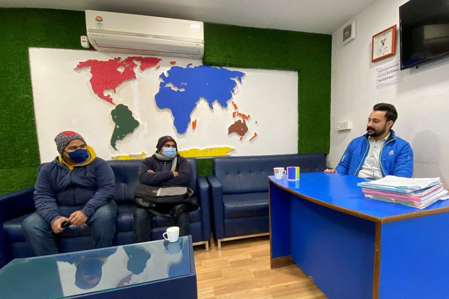 Srijan Upadhyay and Sagar Sharma from the eastern state of Bihar listen to Lovepreet, an immigration counsellor of Blue Line consultants, at his office in Rajpura town in the northern state of Punjab, India, January 21, 2022. Picture taken January 21, 2022. REUTERS/Krishna N. Das