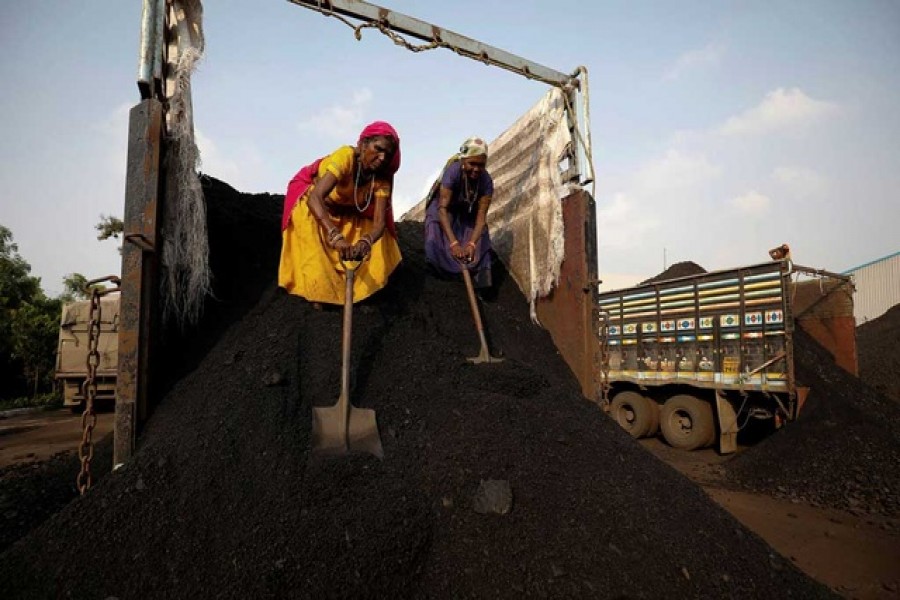 Workers unload coal from a supply truck at a yard on the outskirts of Ahmedabad, India Oct 12, 2021 – Reuters/Amit Dave/File