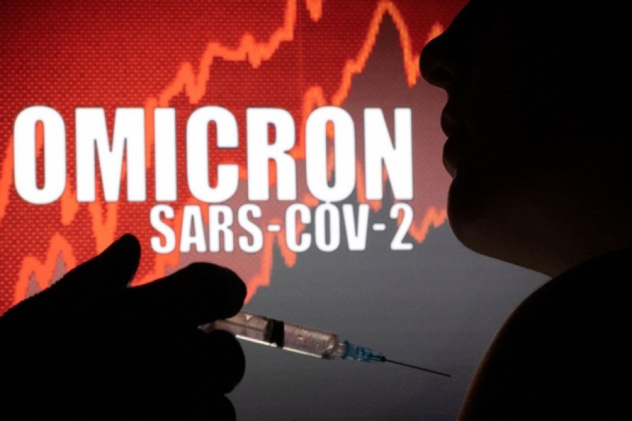 People pose with syringe with needle in front of displayed words "OMICRON SARS-COV-2" in this illustration taken, December 11, 2021 – Reuters/Files