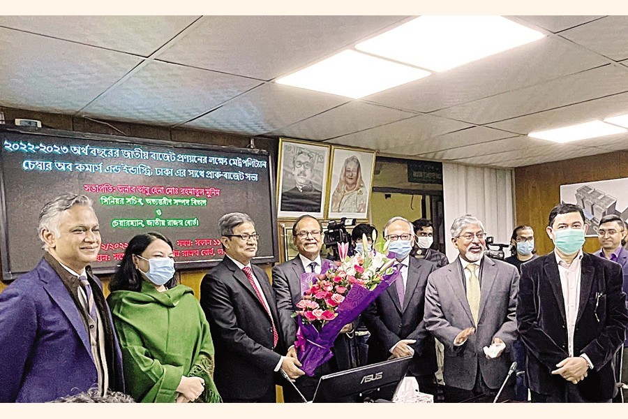 A delegation of Metropolitan Chamber of Commerce and Industry, Dhaka (MCCI) led by its President Md Saiful Islam greets NBR Chairman Abu Hena Md Rahmatul Muneem with a bouquet at a pre-budget discussion at the conference room of NBR in the city on Wednesday