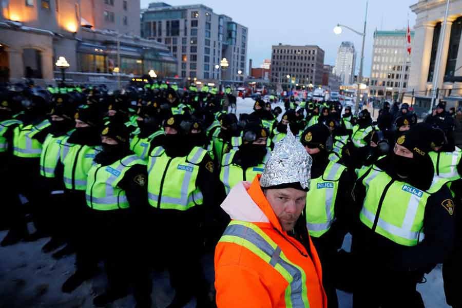 A person wears a tinfoil hat in front of a row of police as truckers and their supporters continue to protest against COVID-19 vaccine mandates in Ottawa of Ontario in Canada on Friday –Reuters photo