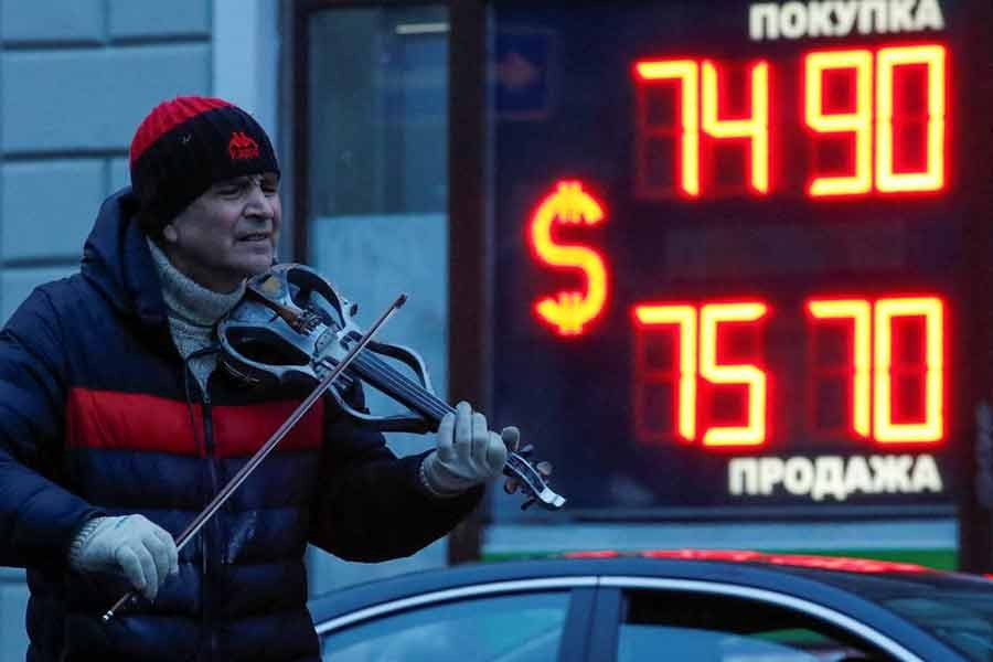 A street performer playing the violin near a board showing currency exchange rates of US dollar against the Russian rouble in Saint Petersburg of Russia on February 16 this year –Reuters file photo