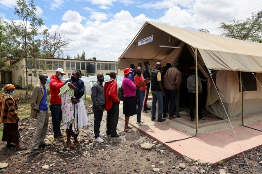 People stand in line to receive a COVID-19 vaccine, at the Narok County Referral Hospital, in Narok, Kenya, December 1, 2021. REUTERS