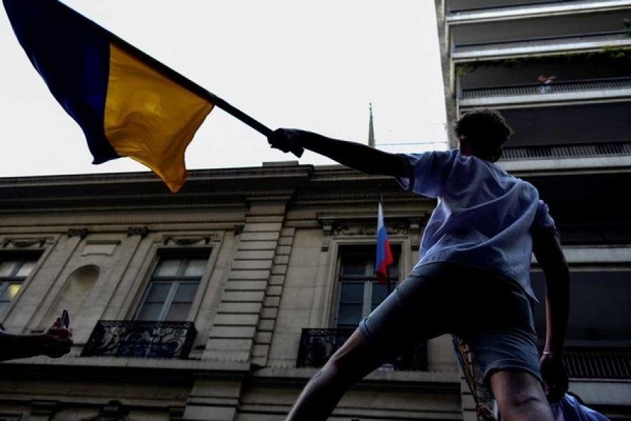 A demonstrator waves a Ukrainian flag while protesting after Russia launched a massive military operation against Ukraine, in Buenos Aires, Argentina Feb 25, 2022 — Reuters/Mariana Nedelcu