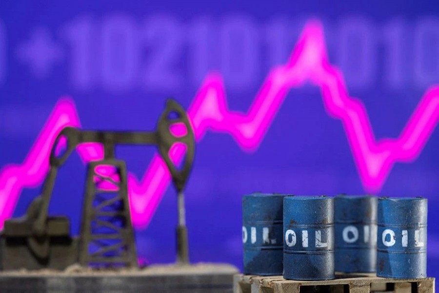 Models of oil barrels and a pump jack are displayed in front of a rising stock graph and "$100" in this illustration taken on February 24, 2022 — Reuters photo