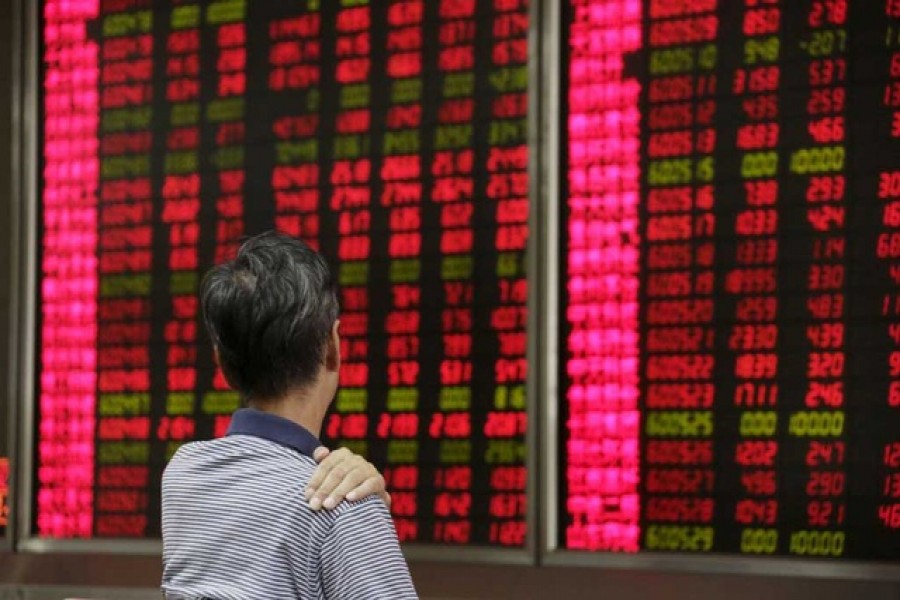 An investor looks at an electronic board showing stock information at a brokerage house in Beijing, August 27, 2015 — Reuters/Files