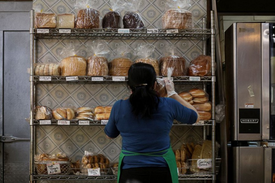 A baker stocks shelfs with bread at the Eastern Market in Washington, US, February 11, 2022. REUTERS/Brendan McDermid/File Photo