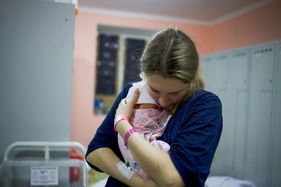 A mother holds her newborn baby in the bomb shelter of a maternity hospital in Kyiv, Ukraine. REUTERS
