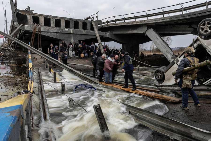 Local residents crossing a destroyed bridge on Monday as they evacuate from the town of Irpin, after days of heavy shelling on the only escape route used by locals, while Russian troops advance towards Kyiv of Ukraine –Reuters photo