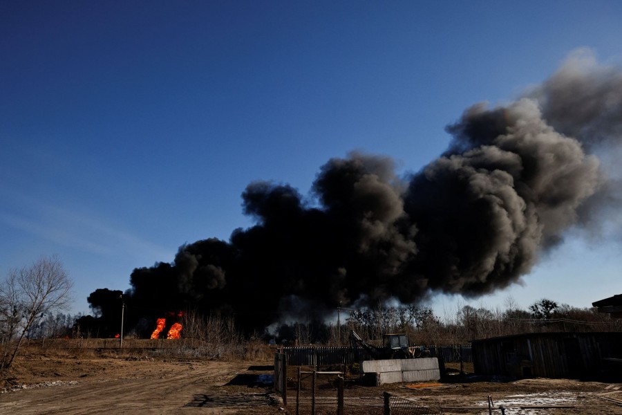 A column of smoke rises from burning fuel tanks that locals said were hit by five rockets at the Vasylkiv Air Base, following Russia's invasion of Ukraine, outside Kyiv, Ukraine, March 12, 2022. REUTERS/Thomas Peter