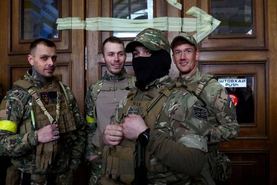 Four foreign fighters from the UK pose for a picture prior to their departure towards the front line in the east of Ukraine following the Russian invasion, at the main train station in Lviv, Ukraine, March 5, 2022 --Reuters/Files