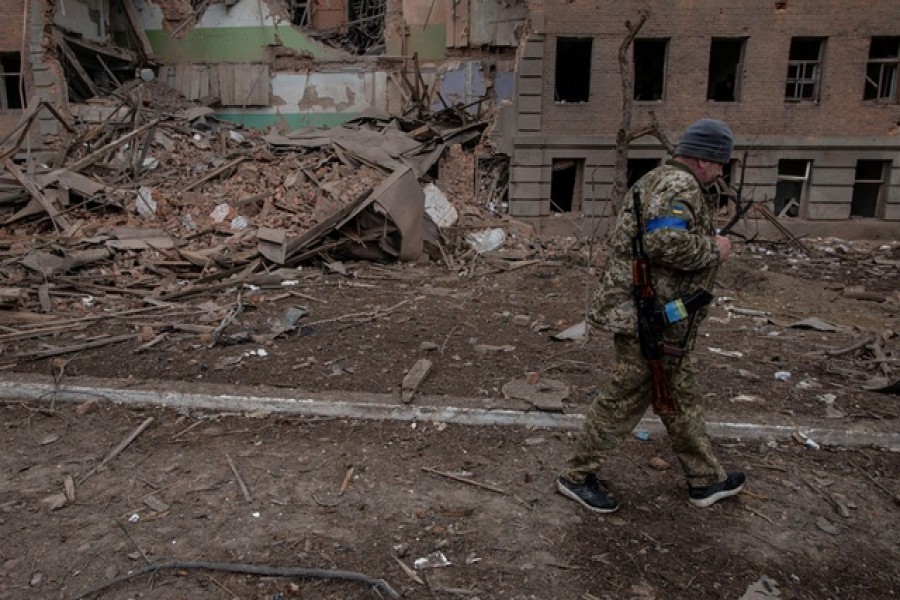 A Ukrainian service member walks past a building destroyed by shelling, as Russia's attack on Ukraine continues, in the town of Okhtyrka, in the Sumy region, Ukraine March 14, 2022. Ukrainian Ground Forces via REUTERS
