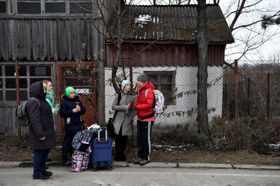 A family wait for transport after fleeing from Ukraine to Romania, following Russia's invasion of Ukraine, at the border crossing in Siret, Romania on March 13, 2022 — Reuters photo