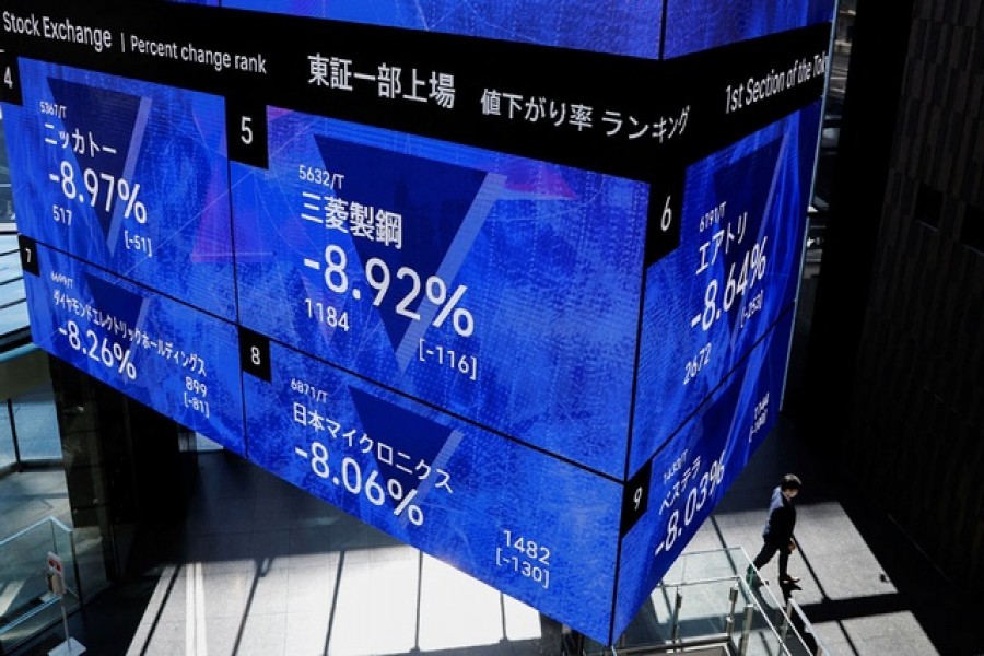 A man wearing a protective face mask walks under an electronic board showing Japan's Nikkei share price index inside a conference hall, amid the coronavirus disease (COVID-19) pandemic, in Tokyo, Japan February 24, 2022 -- Reuters/Files