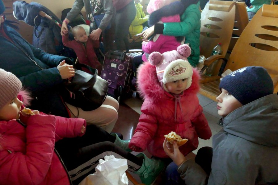 Children eat as people fleeing Mykolaiv gather at the train station, amid Russia's invasion of Ukraine, In Odessa, Ukraine March 9, 2022. REUTERS/Igor Tkachenko