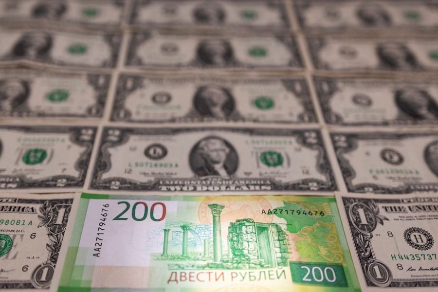 Russian Rouble banknote is placed on U.S. Dollar banknotes in this illustration taken on February 24, 2022 — Reuters/Files