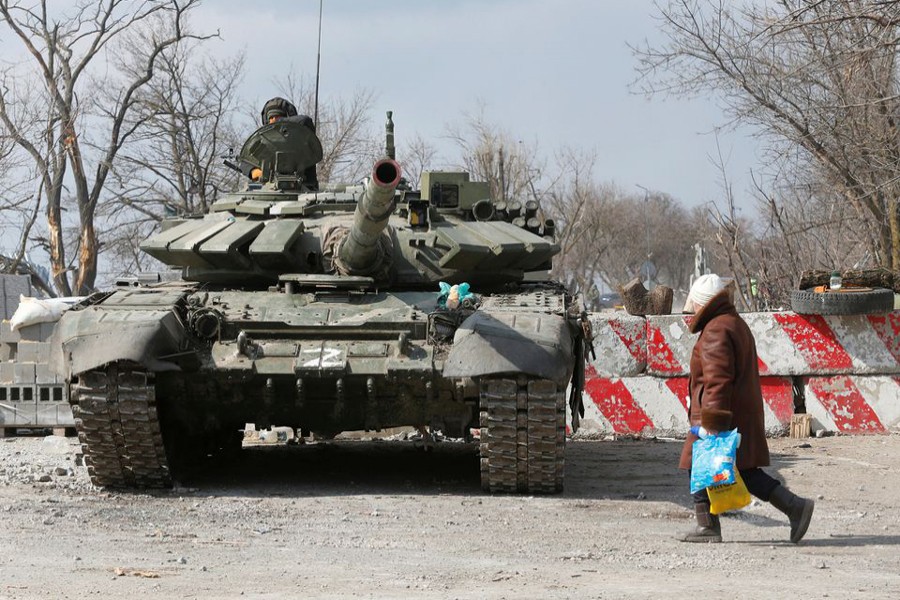 A local resident walks past a tank of pro-Russian troops during Ukraine-Russia conflict in the besieged southern port city of Mariupol, Ukraine on March 18, 2022 — Reuters photo
