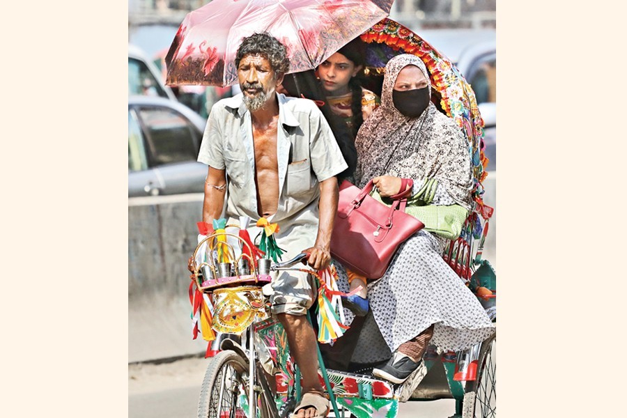 Passengers using an umbrella while riding on a rickshaw as the country has been experiencing a hot and humid weather — FE/Files