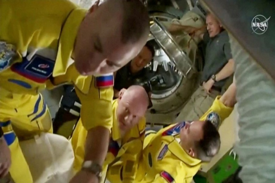 Russian cosmonauts Oleg Artemyev, Denis Matveev and Sergey Korsakov arrive wearing yellow and blue flight suits at the International Space Station after docking their Soyuz capsule March 18, 2022 i a still image from video. Video taken March 18, 2022. NASA TV/Handout via REUTERS.