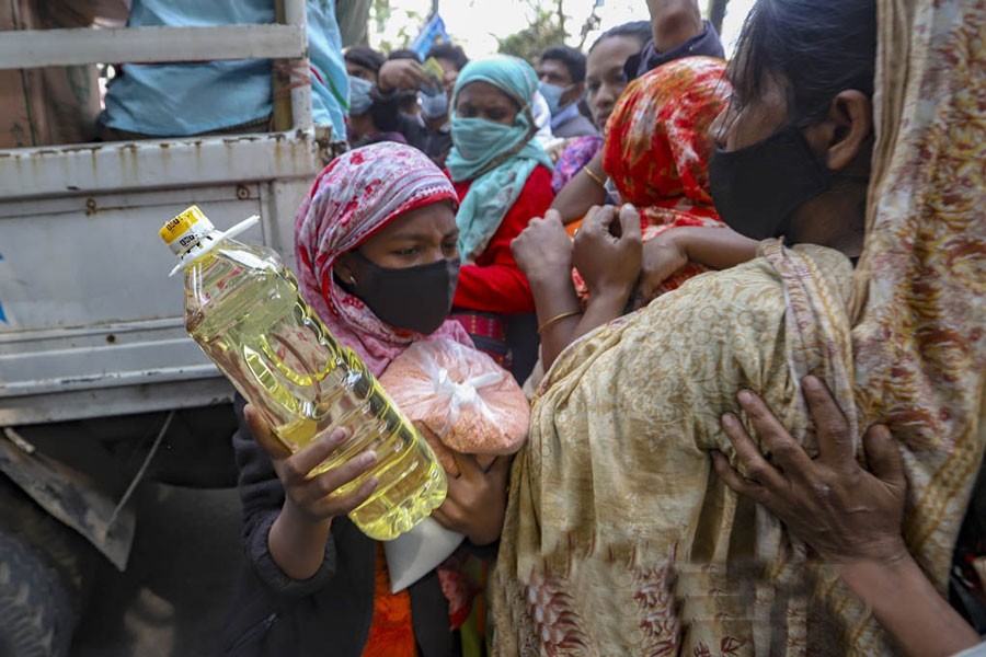 A woman leaves after buying goods sold by a dealer of the Trading Corporation of Bangladesh at low cost following a long wait outside the railways ministry in Dhaka. 	—Photo: bdnews24.com