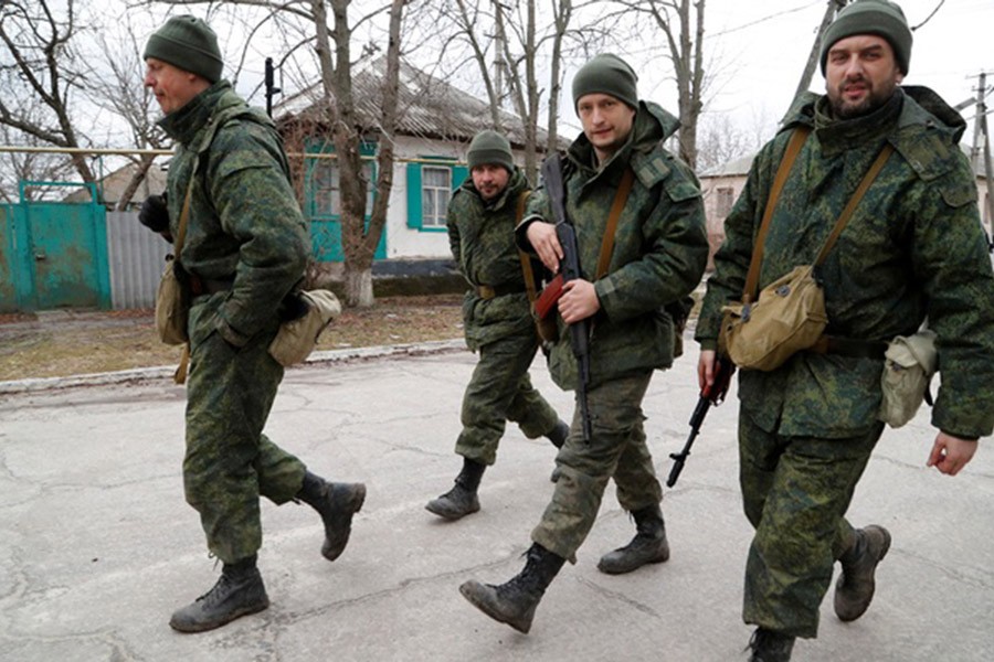 Servicemen of pro-Russian militia walk along a street in Stanytsia Luhanska in the Luhansk region, Ukraine February 27, 2022. REUTERS/Alexander Ermochenko