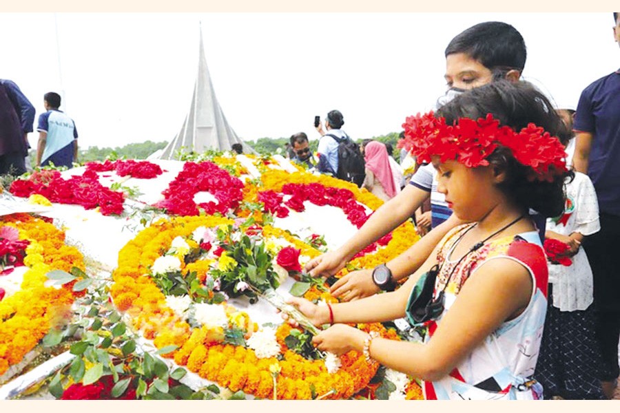 Children lay a wreath in memory of the fallen heroes of the Liberation War on Independence Day at the National Memorial in Savar 	—bdnews24.com photo