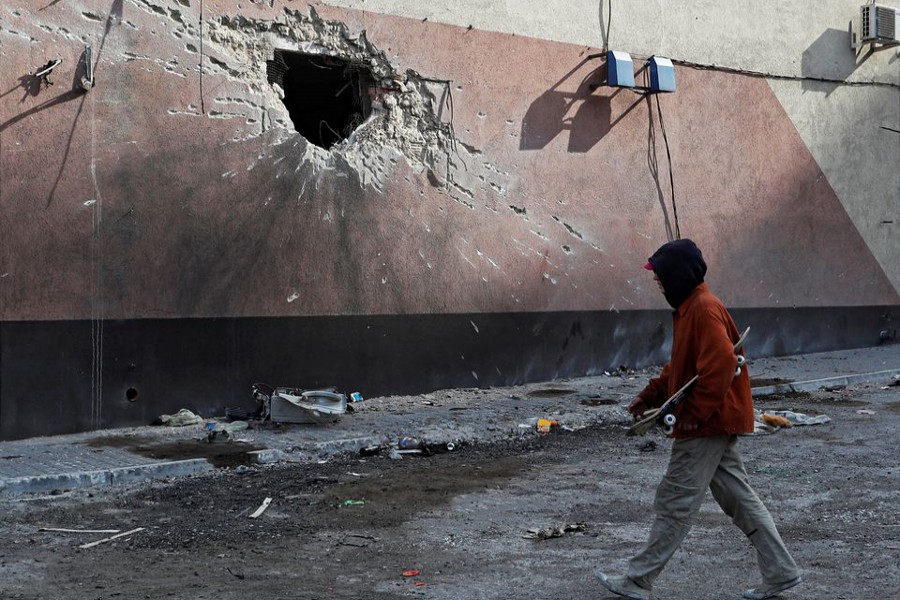 A local resident walks past a building damaged during Ukraine-Russia conflict in the besieged southern port city of Mariupol, Ukraine on March 31, 2022 — Reuters photo