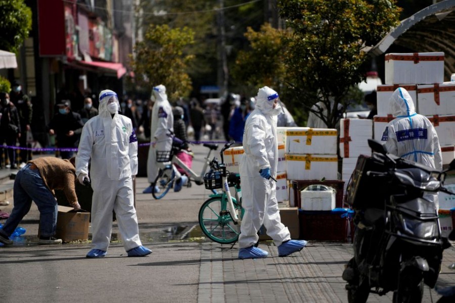 Police and security members in protective suits stand outside cordoned off food stores following the coronavirus disease (COVID-19) outbreak in Shanghai, China March 29, 2022. REUTERS/Aly Song/File Photo