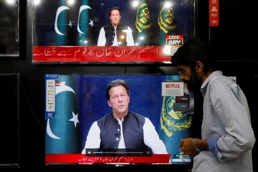 A shopkeeper tunes a television screen to watch the speech of Pakistani Prime Minister Imran Khan, at his shop in Islamabad, Pakistan, Mar 31, 2022. REUTERS/Akhtar Soomro