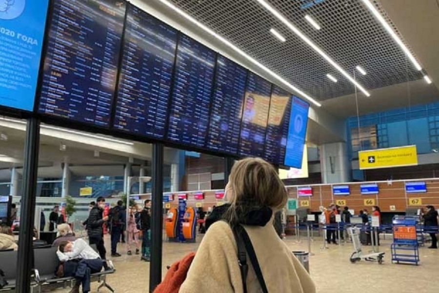 A passenger looks at a departures board at Sheremetyevo airport, after Russia closed its airspace to airlines from 36 countries in response to Ukraine-related sanctions targeting its aviation sector, in Moscow, Russia February 28, 2022. REUTERS/Stringer/File Photo