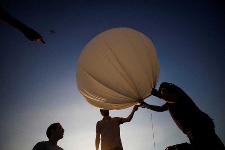 People hold a balloon during a demonstration by Israeli startup High Hopes Labs who are developing a balloon that captures carbon directly from the atmosphere at a high altitude, in Petah Tikva, Israel November 3, 2021. REUTERS/Amir Cohen/File Photo