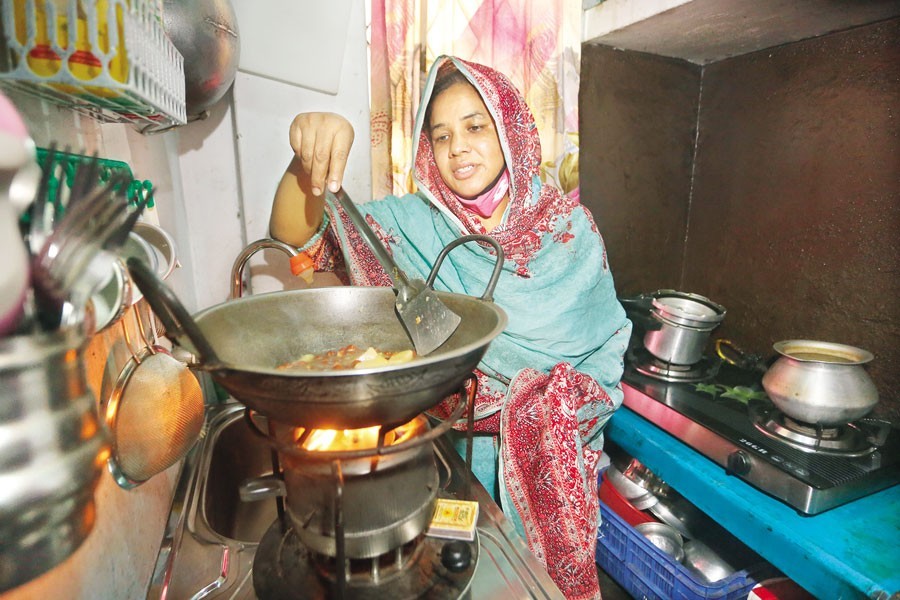 This woman uses a kerosene-fuelled stove to cook food at a house in Dhaka's Shantibagh area on Monday as shortage of gas supply for the second consecutive day during the month of Ramadan hampered city life — FE photo by KAZ Sumon