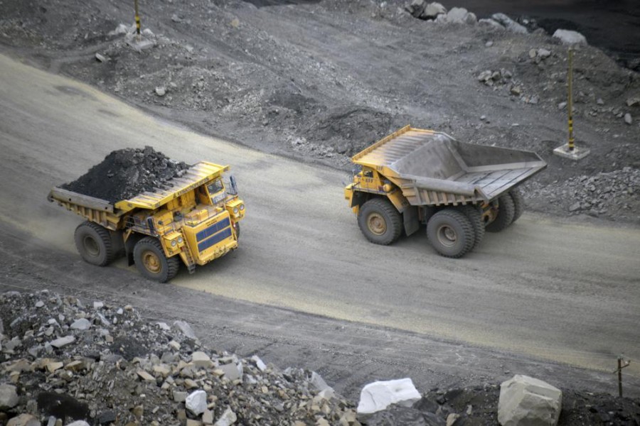 FILE - A loaded dump truck passes an empty truck as it carries away coal at the Kedrovsky open-pit coal mine in Kemerovo, Russia, Tuesday, June 16, 2015. (AP Photo/Phelan M. Ebenhack, File)