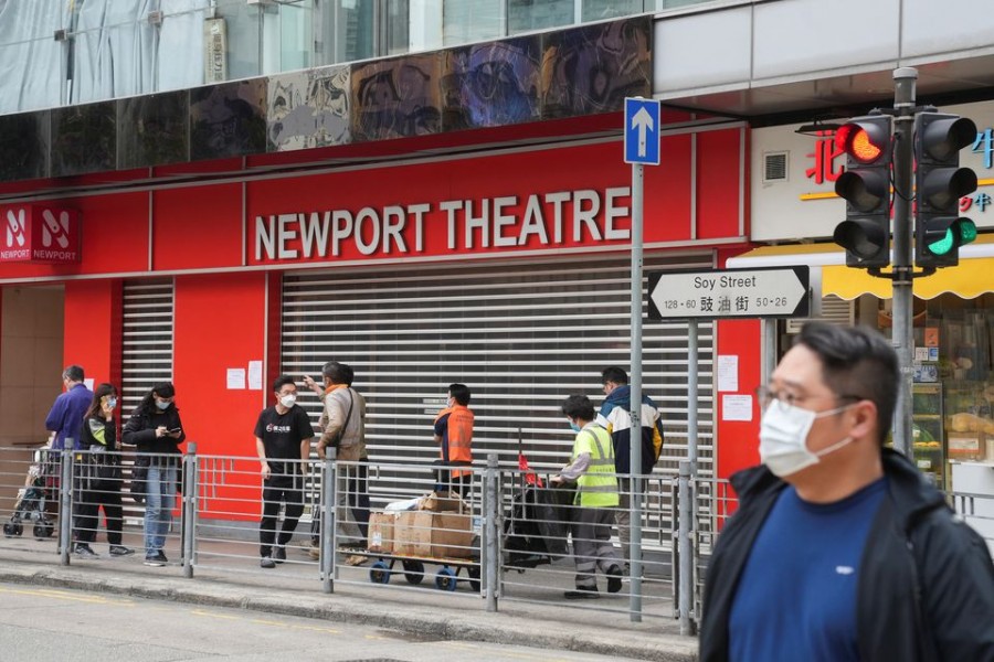 People wearing face masks, following the coronavirus disease (Covid-19) outbreak, walk past a closed cinema in Hong Kong, China on February 16, 2022  — Reuters/Files