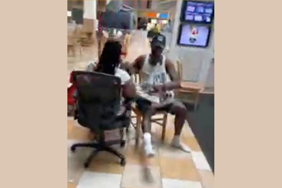 People sit at a shopping mall in the aftermath of a shooting that took place at the mall, in Columbia, South Carolina, April 16, 2022, in this screengrab from a video obtained from social media. SC Lash Extensions via REUTERS