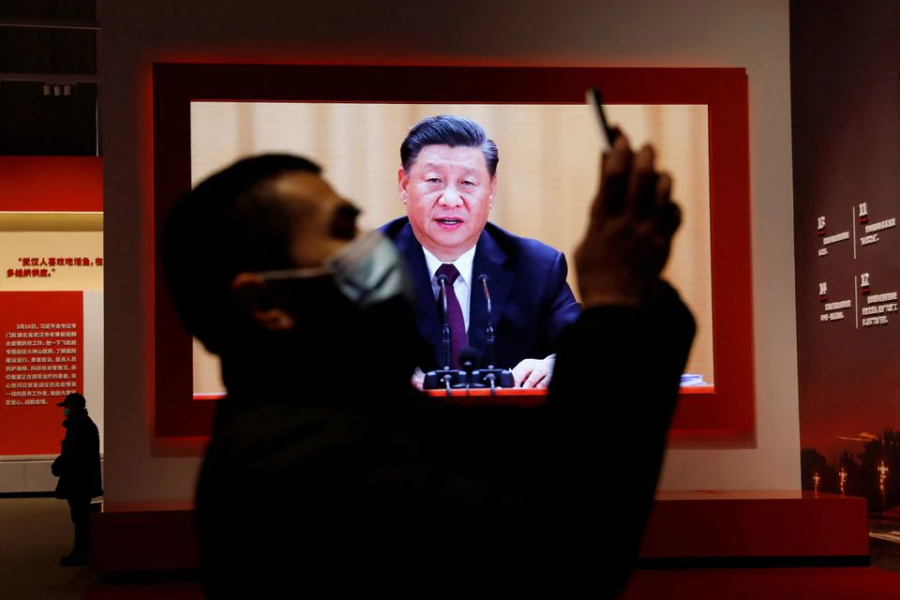 A visitor holds his mobile phone near a screen showing Chinese President Xi Jinping during an exhibition on the fight against the coronavirus disease (Covid-19) outbreak, at Wuhan Parlor Convention Center in Wuhan, Hubei province, China on December 31, 2020 — Reuters/Files