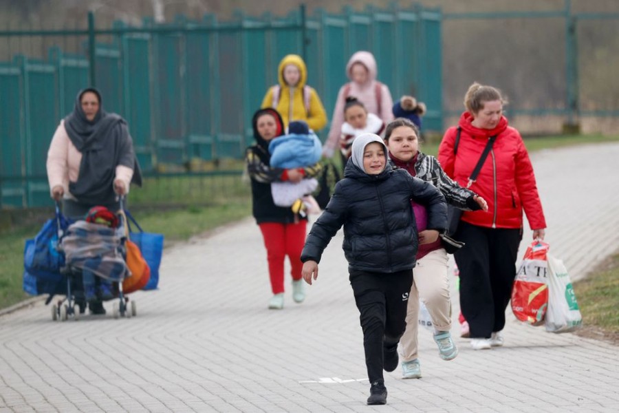 Ukrainian refugees walk after crossing the Ukraine-Poland border, amid the Russian invasion of Ukraine, in Medyka near Przemysl, Poland, April 10, 2022. REUTERS/Leonhard Foeger