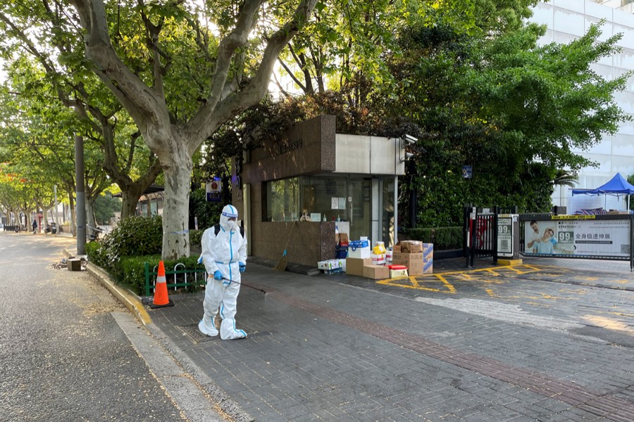 A worker in protective suit disinfects the ground in front of a residential compound amid the Covid-19 outbreak in Shanghai, China on April 21, 2022 — Reuters photo