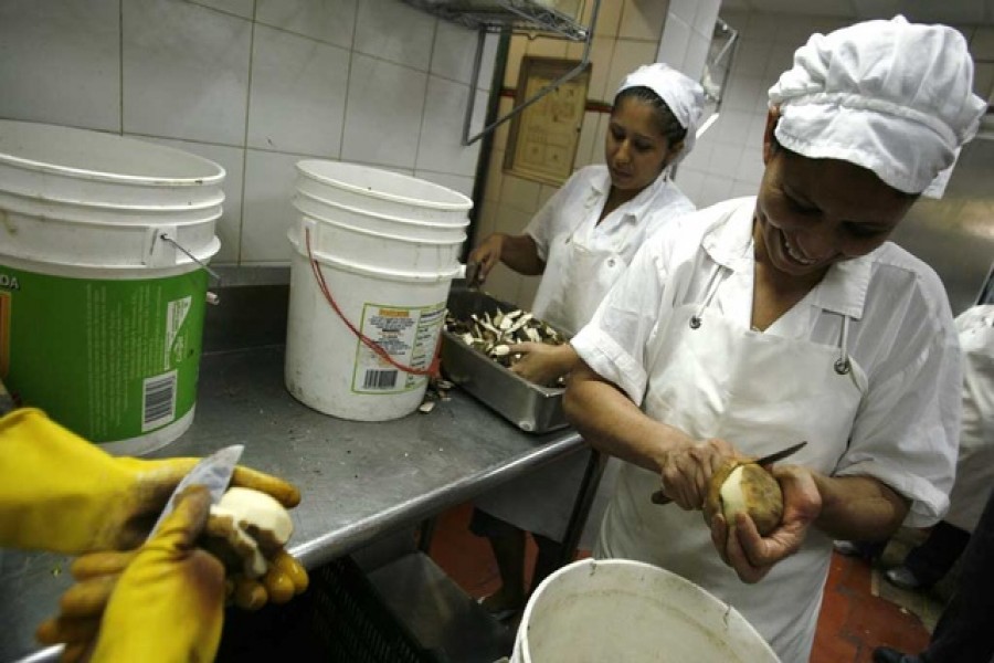 Women peel potatoes at a restaurant in Caracas, Aug 15, 2007 – Reuters/Carlos Garcia Rawlins