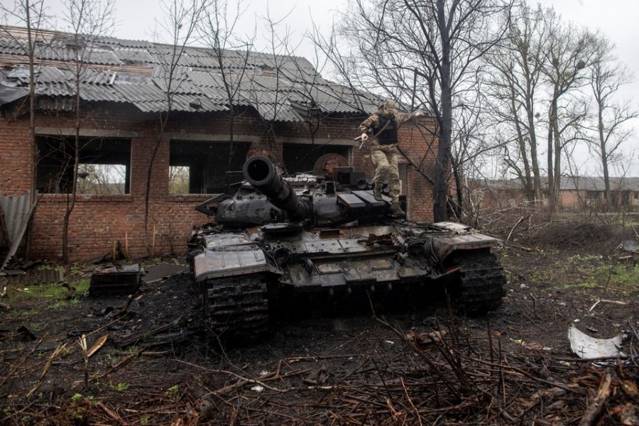 A Ukrainian soldier jumps of a destroyed Russian tank on the outskirts of the village of Mala Rohan, amid Russia's invasion of Ukraine, in Kharkiv region, Ukraine, April 20, 2022. Picture taken April 20, 2022. REUTERS/Alkis Konstantinidis