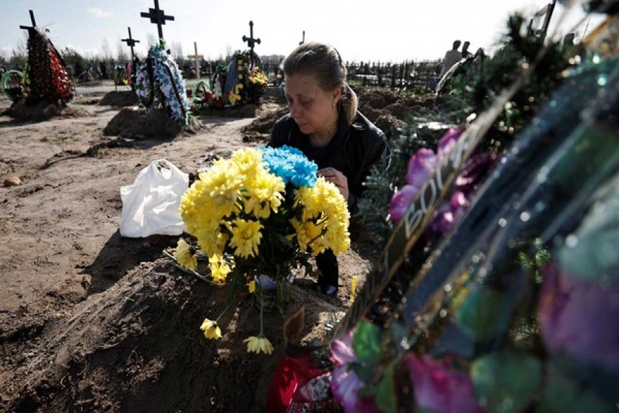 Irina Tromsa, 50, who said her son Bohdan Tromsa, 25, a territorial defence member, was killed by Russian troops on the frontline near Sumy, mourns by his grave day after his burial at the cemetery in Bucha, amid Russia's invasion of Ukraine, Kyiv region, Ukraine Apr 24, 2022. REUTERS/Zohra Bensemra