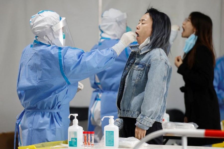 Medical workers in protective suits collect swabs samples from residents at a makeshift nucleic acid testing site amid a mass testing for the coronavirus disease (COVID-19) in Chaoyang district of Beijing, China April 27, 2022. REUTERS/Carlos Garcia Rawlins