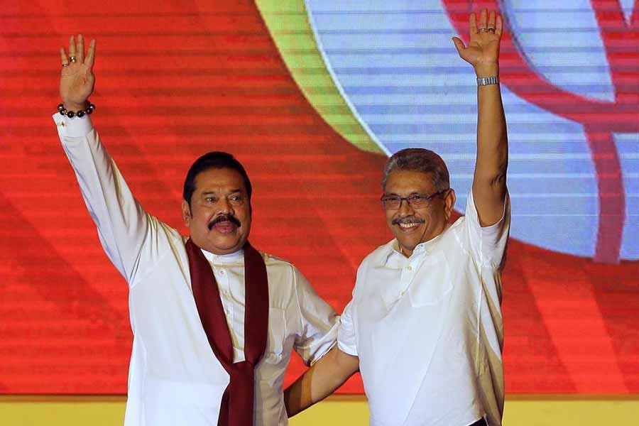 Mahinda Rajapaksa, left, and his brother Gotabaya Rajapaksa waving to supporters during a party convention in Colombo on August 11 in 2019 –AP file photo